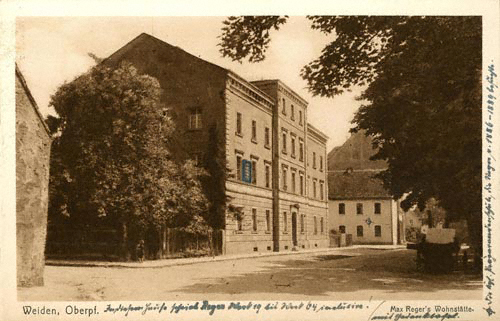 Max Regers Wohnung in Weiden mit Gedenktafel (auf der Postkarte markiert), mit eigenhändiger Beschriftung von  ([unten:] »In diesem Hause schrieb Reger Werk  bis Werk 64 inclusive!«; [rechter Rand, von unten nach oben:] »Die kgl. Präparendenschule [sic], die Reger v. – besuchte«, Max-Reger-Institut, Karlsruhe, Fotoalbum Elsa Regers.